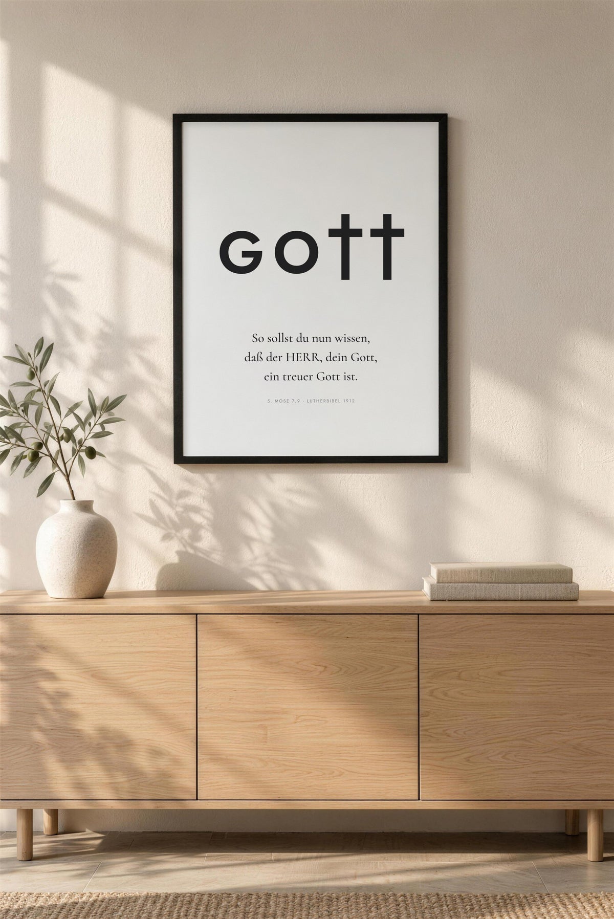 Poster GOTT mit dem Vers aus 5. Mose 7,9 im schwarzen Rahmen über einem Eichen-Sideboard