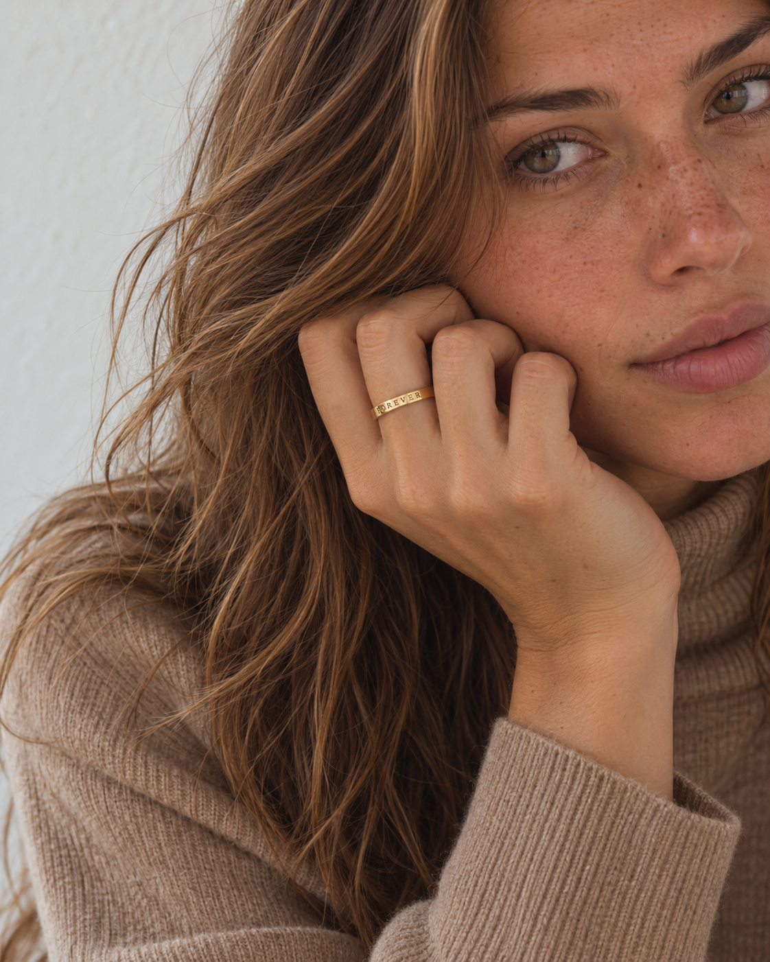 VEDA Ring mit Namensgravur Gold – an der Hand an der Wange – Lorelia